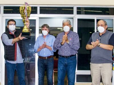 Alberto Antebi recibió la enorme copa “Independencia” de manos del titular del Jockey Club, Gustavo Pedrozo.