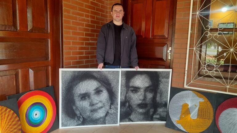 Derlis Olmedo, mostrando los retratos de hilos de Berta Rojas y Nadia Ferreira.