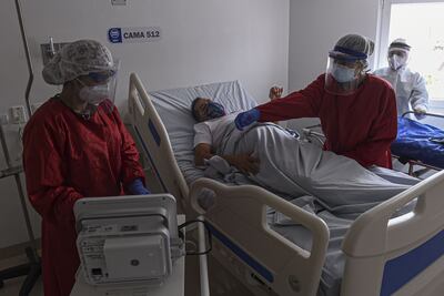 Trabajadores de la salud asisten a un enfermo con coronavirus internado en el Hospital General de Medellín, en Colombia.