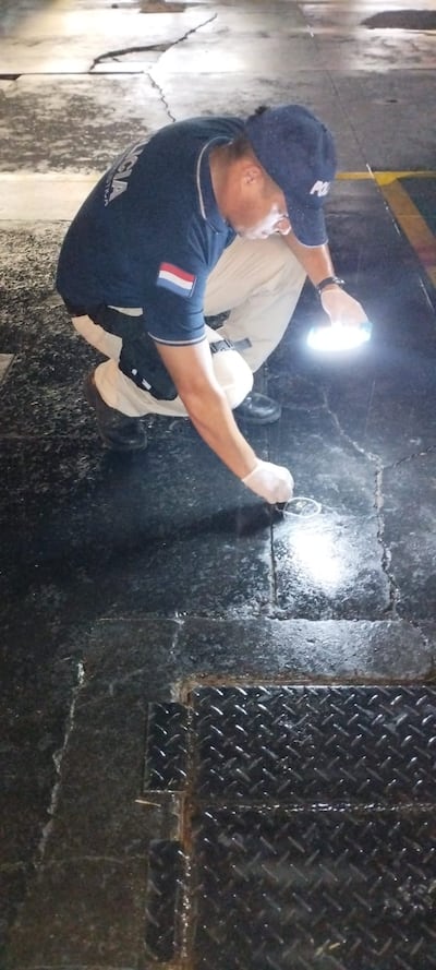 Un agente de Criminalística levanta evidencias de la escena del crimen, en plena avenida España esq. Pitiantuta.