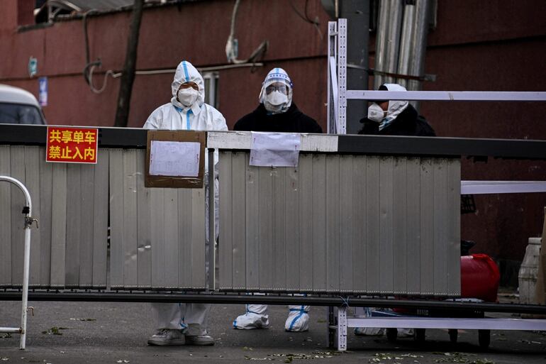 Trabajadores de salud y seguridad en la entrada a una zona residencial en aislamiento en Pekín, este martes.