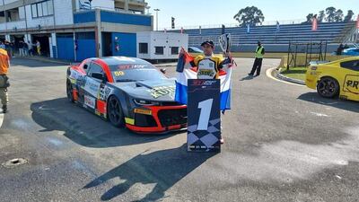 El piloto paraguayo Óscar Bittar posa con su trofeo y la bandera paraguaya tras el triunfo obtenido ayer en la primera carrera de la categoría AM del Sprint Race de Curitiba, en Brasil.