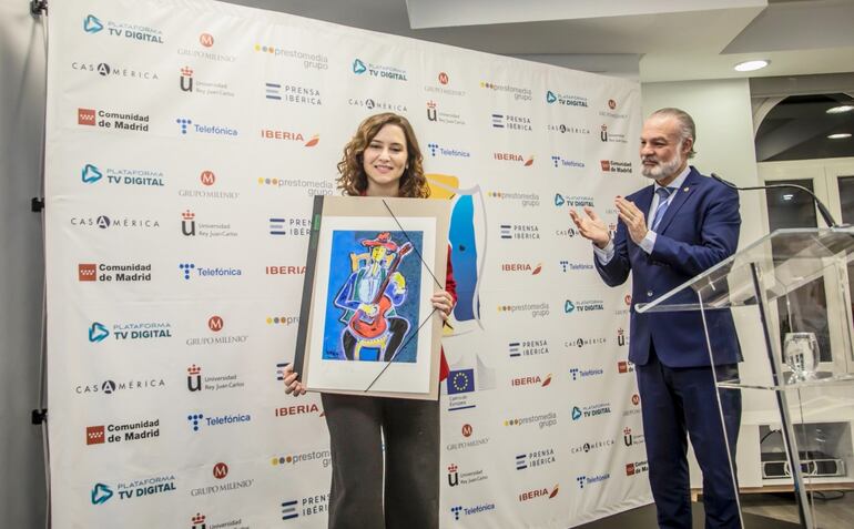 La presidente de la Comunidad de Madrid, Isabel Díaz Ayuso recibe un presente de Prestomedia, organizador del evento.