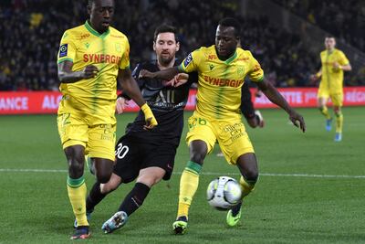 Messi es frenado por dos jugadores del Nantes; Dennis Appiah (i) y Osman Bukari .