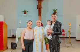 Los orgullosos papás de Lía Arami, Ara Yambay y Santiago Rojas, posan con la beba junto al sacerdote que la bautizó.