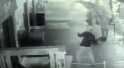 Momento en el que el ladrón arroja una piedra contra la puerta de blíndex del restaurante Tío Lucas.