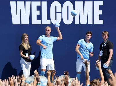 Haaland, junto al argentino Julián Álvarez, lanzando balones de obsequios a los aficionados del Manchester City durante el acto de presentación.