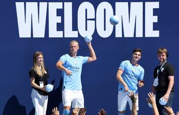 Haaland, junto al argentino Julián Álvarez, lanzando balones de obsequios a los aficionados del Manchester City durante el acto de presentación.