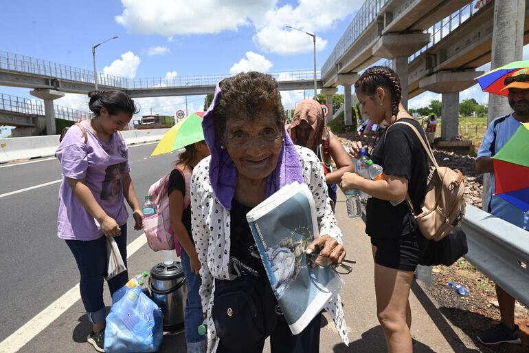 Doña Deolinda Candado a sus 79 años desafía el rigor del calor en la soporífera siesta en el camino a Caacupé. 