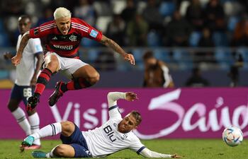 El brasileño Pedro, de Flamengo, salta y esquiva el tackle del colombiano Gustavo Cuéllar, de Al Hilal, durante el partido disputado ayer en Marruecos.
