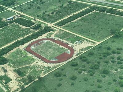 Foto aérea de lo que es la primera pista de atletismo en el Chaco. Arriba, la inspección de las autoridades.