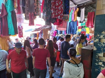 Gran cantidad de personas y vendedores colman los pasillos y veredas del Mercado 4. En este caso, una vendedora tapona una boca hidrante a la derecha. Esta vereda debería estar despejada.