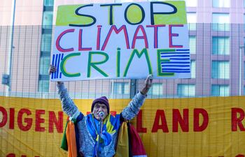 Un activista climático sostiene un cartele en una manifestación fuera del perímetro de seguridad de la COP26.