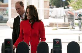 El príncipe Guillermo y su esposa Kate validan una entrada al metro de Londres, medio de transporte que utilizaron para llegar a un pub londinense.