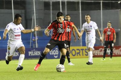 Julio Enciso (c) controla la pelota frente a Farid Díaz (i).