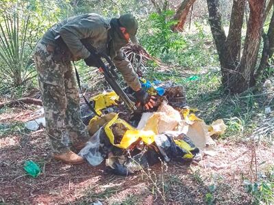 Un efectivo de la Armada Paraguaya verifica el cargamento de marihuana prensada hallada cerca del lago de Itaipú.