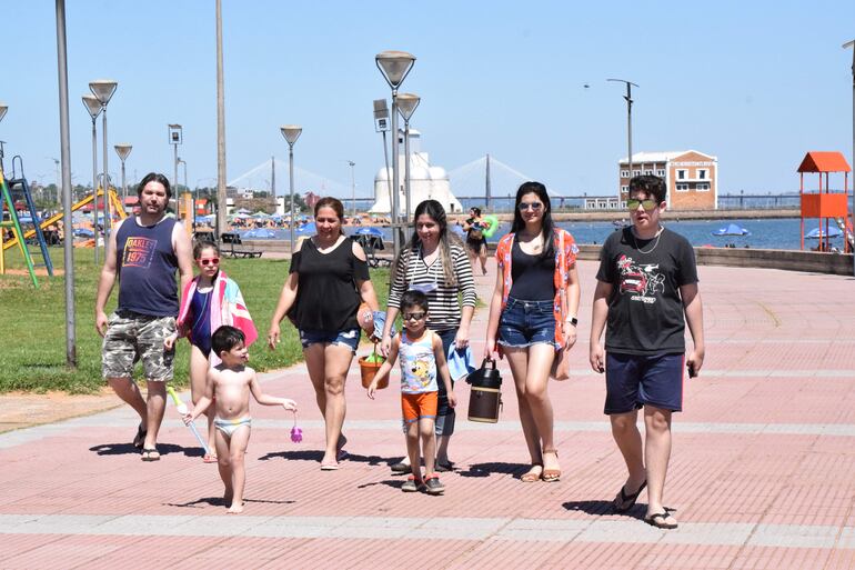 Una familia proveniente de Asunción aprovecha la atractiva vía peatonal de la playa San José para dar un relajante paseo bajo el sol.