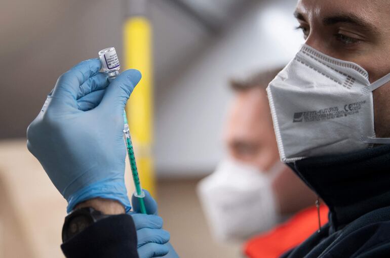 Un personal médico prepara una dosis de vacuna anticovid.