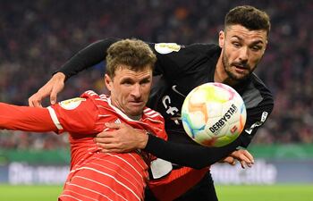 Thomas Mueller (i), del Bayern Munich, disputa el balón con Manuel Gulde, del Friburgo.