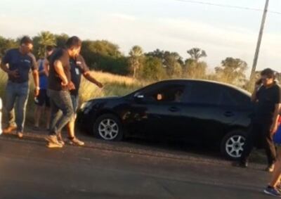 Curiosos rodean el auto en cuyo interior quedó la víctima.