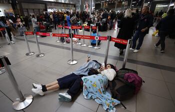 Personas esperan hoy, en el aeropuerto El Dorado, tras el cierre de operaciones de la aerolínea Viva Air, en Bogotá (Colombia). La incertidumbre y la indignación reina este martes en los principales aeropuertos colombianos por la cancelación de operaciones de la aerolínea de bajo coste Viva Air, que dejo en tierra a miles de pasajeros los cuales protestan en las terminales aéreas para exigir soluciones.