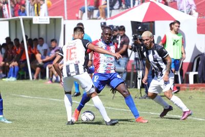 El extremo colombiano Gustavo Cañizales busca filtrarse entre las marcas de Héctor Lozano y Justo González del Deportivo Santaní. (Foto: APF)