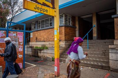 Los peatones pasan por la fachada rota de la estación de tren de Jeppe Street, en el centro de Johannesburgo.