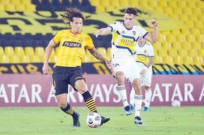 Williams Riveros (i) y Nicolás Capaldo disputan el balón durante el choque de ayer. AFP