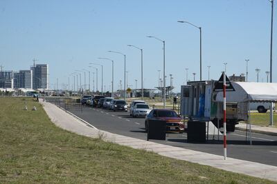 Uno tras otro, los vehículos aguardan en la fila sobre la avenida Costanera para que sus conductores se hagan el test de Covid-19.