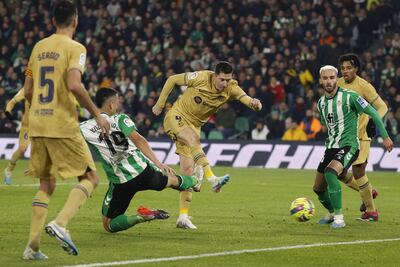El delantero del Barcelona Robert Lewandowski (c) chuta para marcar el segundo gol ante el Betis, durante el partido de Liga en Primera División entre Real Betis y FC Barcelona disputado ayer miércoles en el estadio Benito Villamarín, en Sevilla. EFE/Julio Muñoz