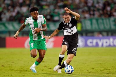 Luis Marquines (i) futbolista de Atlético Nacional, lucha por el balón con Facundo Zabala, jugador de Olimpia, en el duelo por la tercera fecha del Grupo H de la Copa Libertadores en el estadio Atanasio Girardot, en Medellín, Colombia.