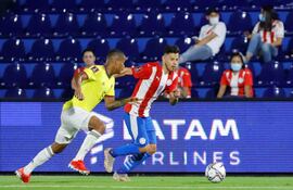 Ángel Romero (d) de Paraguay disputa hoy el balón con Wilmar Barrios de Colombia, durante un partido por las eliminatorias sudamericanas para el Mundial de Catar 2022, en el estadio Defensores del Chaco en Asunción (Paraguay). EFE