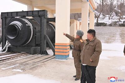 El líder norcoreano Kim Jong-un (a la derecha) observa un motor de cohete en la base de lanzamiento Saikai, en la provincia de Pyongan del Sur.