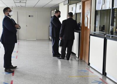 El periodista Juan Carlos Lezcano (i), de ABC Color, aguarda mientras el exsenador Dionisio Amarilla (PLRA, llanista), quien lo demandó por supuesta calumnia, difamación e injuria, conversa con el abogado del primero, Rodrigo Yódice.