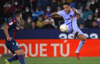 El delantero gabonés Pierre-Emerick Aubameyang, del Barcelona, salta y controla el balón ante la presencia del defensor español Rober Pier, del Levante.