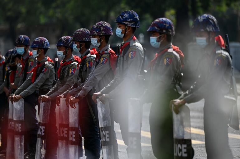 Policías antidisturbios montan guardia ante una manifestación contra el golpe de Estado militar en Birmania, este domingo en Rangún.