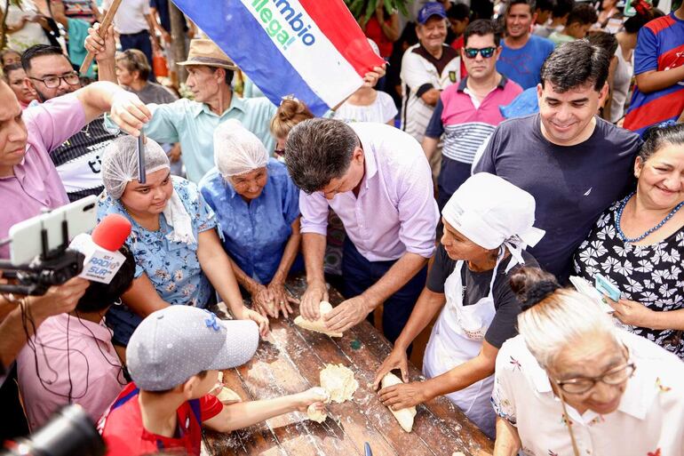 Efraín Alegre, a la par de las guapas mujeres guarambareñas, prepara la masa para el tradicional chipa.