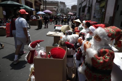 Vendedores y clientes comercian en una calle de Lima (Perú). Las protestas antigurbernamentales en Lima comienzan a apaciguarse y los comerciantes ambulantes devuelven el color navideño a la capital peruana, mientras retoman su sitio tradicional en las calles para, como cuenta la vendedora Sandra, "recuperar la plata" invertida en la campaña.