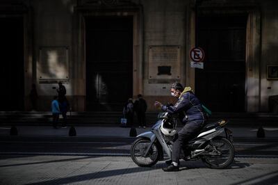 Personas esperan hoy a la entrada de un banco, en Buenos Aires (Argentina).