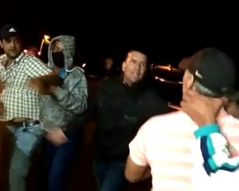 El precandidato a la intendencia Roque Ozusa de camisa acuadrito y kepi forcejeando durante la batalla campal frente a la comisaría de la Colonia Fulgencio Yegros de Quyquyhó.
