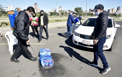 Jóvenes procedían a desinfectar las bolsas recibidas. Las personas acudieron en autos.