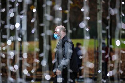 Un hombre con mascarilla camina junto a decoraciones navideñas en Frankfurt, Alemania.