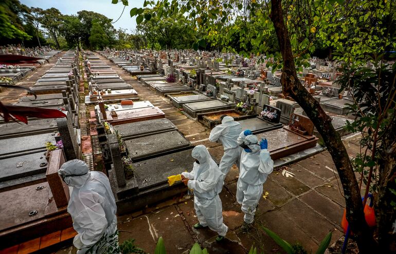 Trabajadores preparan el entierro de una víctima de covid-19 en el cementerio Sao Joao de Porto Alegre, Brasil.