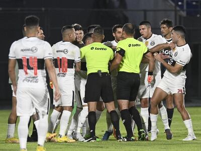 El árbitro Giancarlos Juliadoza (d) rodeado por los jugadores de Olimpia después de sancionar el penal a favor de Libertad y expulsar a Alfredo Aguilar.
