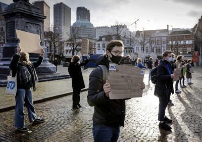 Un estudiante sostiene un cartel con la frase "prometo no volver a rabonearme", en una manifestación que pide el reinicio de las clases en Holanda.