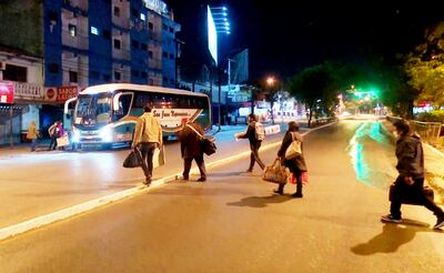 Los pasajeros cruzan la calle con sus bolsones para subir a los buses que parten desde fuera de la Terminal.