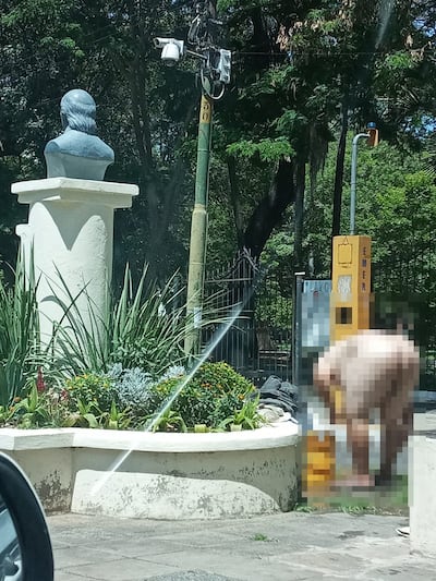Con la ayuda de un balde, un hombre totalmente desnudo busca aplacar el intenso calor en la fuente ubicada en 25 de mayo y México.