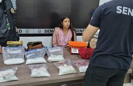 Agentes antidrogas realizan la verificación de lo incautado, ante una mujer que asegura fue engañada en México.