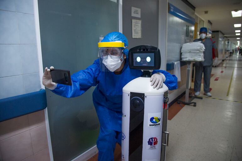 Un trabajador sanitario se toma una foto con LaLuchy Robotina.