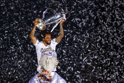 El capitán del Real Madrid Marcelo Vieira levanta la copa tras poner una bufanda a la diosa Cibeles durante la celebración con los aficionados de la victoria del equipo en la final de la Liga de Campeones.